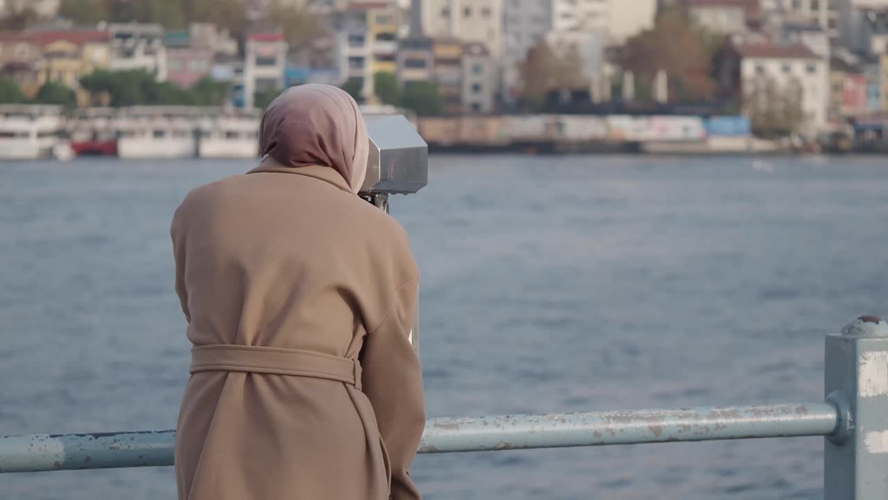 Woman in hijab looking at city view