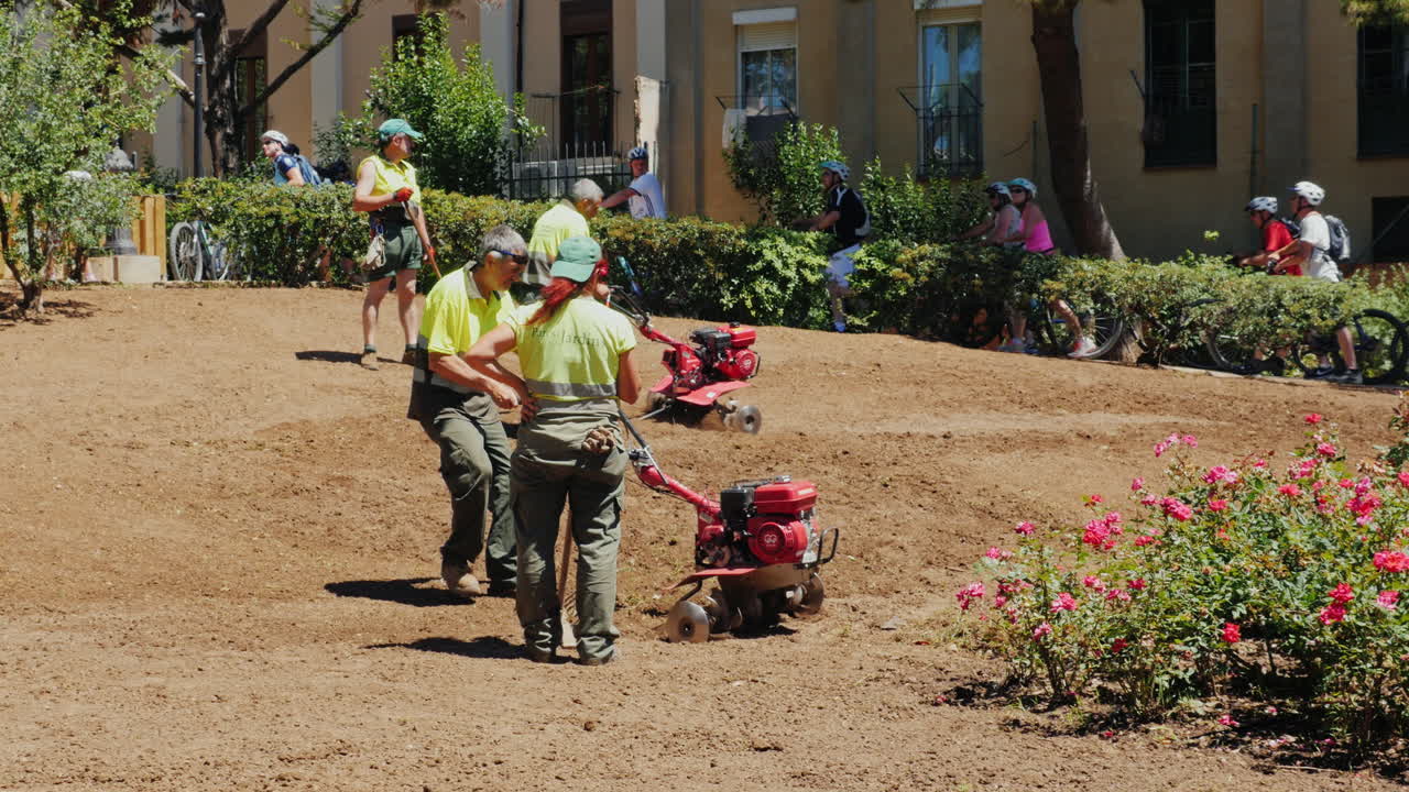 barcelona españa - 20 de junio de 2016 jardineros municipales que trabajan en el macizo de flores cultivan la tierra culti