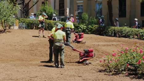 barcelona spain - june 20 2016 municipal gardeners working in the flowerbed cultivate the land culti