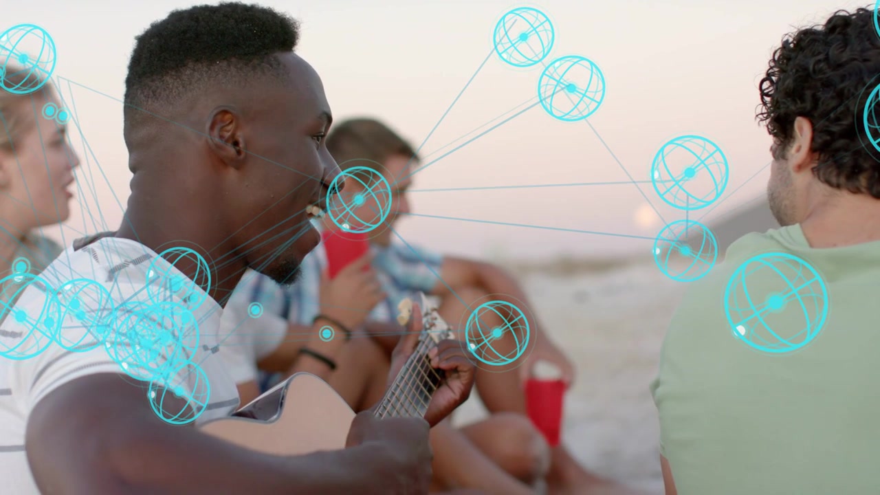 Male guitarist picking up guitar strumming singing beachside leading music with blue net over group