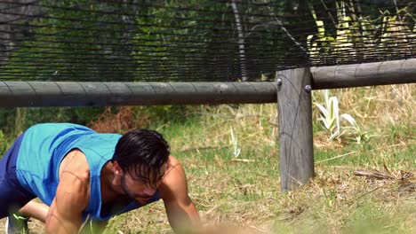 Hombre-Arrastrándose-Bajo-La-Red-Durante-La-Carrera-De-Obstáculos.