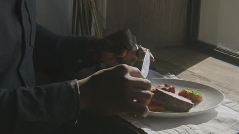 man eating a meal by the window