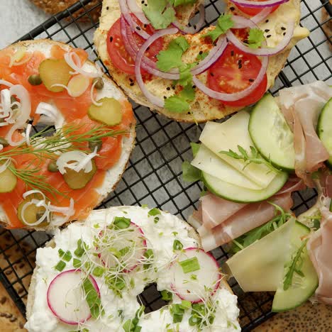 Leckere-Bagel-Sandwiches-Mit-Cremigem-Käse-Schinken-Hummus-Lachs-und-Gemüse