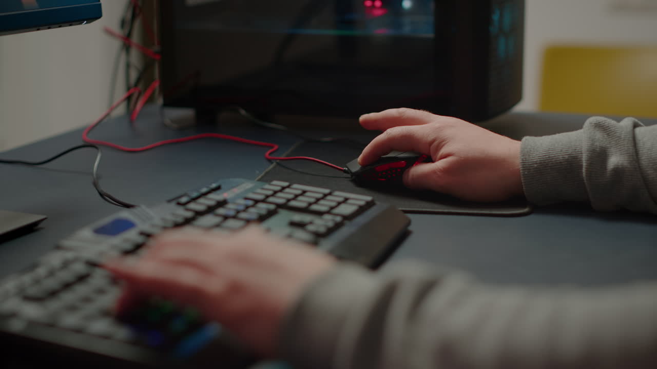 disparo de manos cercanas de un jugador que escribe en un teclado rgb