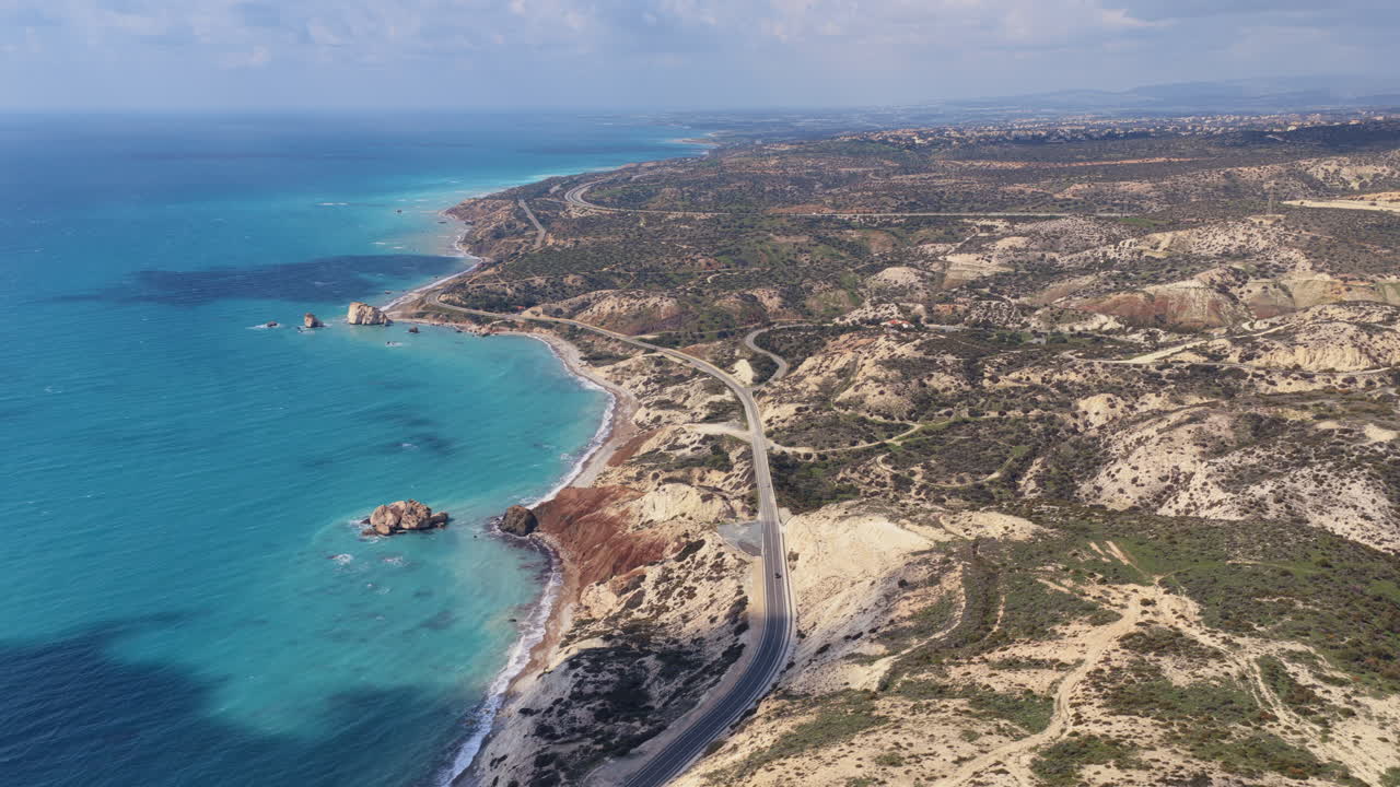 Vista aerea da drone della costa di Cipro con colline ondulate, strade costiere e acque turchesi del Mediterraneo.