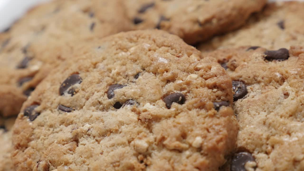 un montón de pasteles de chispas de chocolate de primer plano inclinado 4k 2160p 30fps video ultrahd - galletas con pedazos de chocolate 4k 3840x2160 uhd imágenes de inclinación lenta