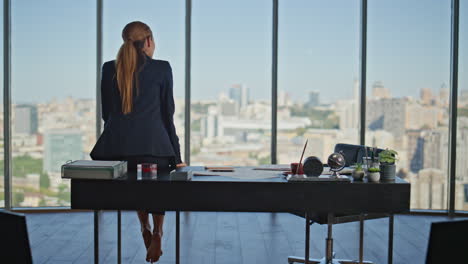 office woman resting workplace sitting on desk barefoot. pensive calm manager