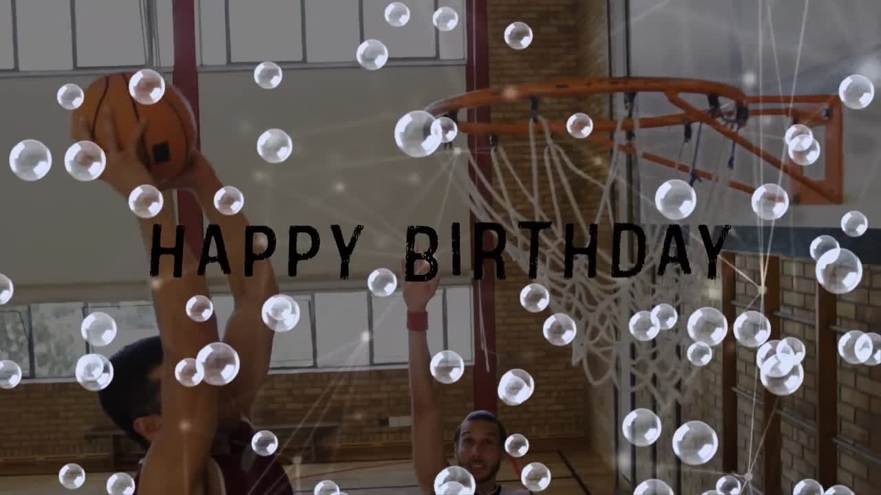 animación de feliz cumpleaños texto y burbujas sobre un grupo diverso de jugadores de baloncesto en el gimnasio