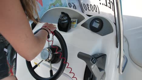 close-up of a young woman steering a motorboat