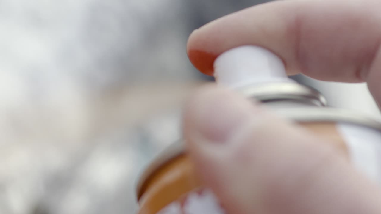 una lata de pintura en aerosol en la mano