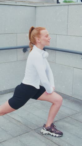 a young woman engaging in a lunge exercise outdoors, demonstrating proper form and fitness apparel while wearing headphones for an enhanced workout experience