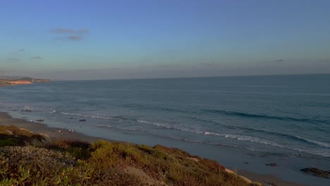 Crystal-Cove-State-Park-in-Corona-Del-Mar-California-panning-right-view-of-the-safety-railing,-rocks,-cliffs,-and-small-waves-of-the-pacific-ocean