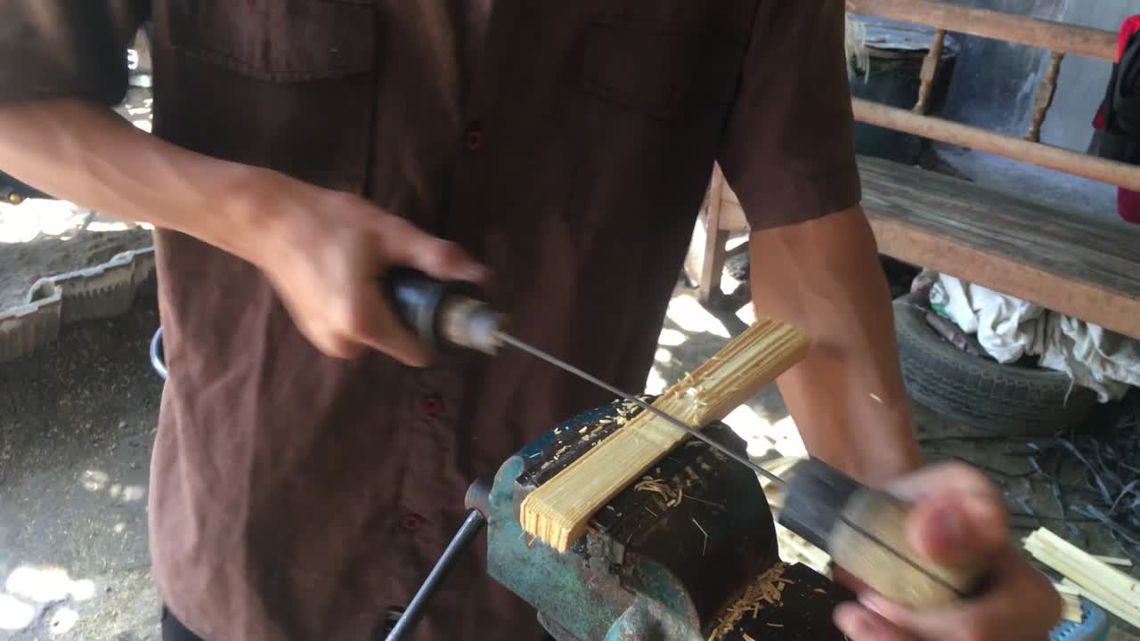 Artisan Crafting Bamboo Strips with Hand Tools and a Vice