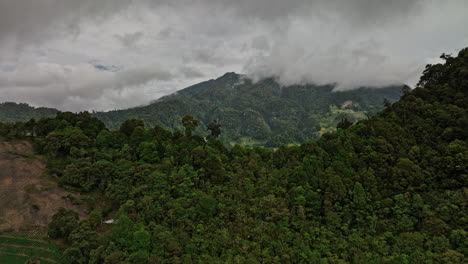 Cerro-Punta-Panama-Aerial-v1-flyover-mountain-ridge-reveals-cultivated-farmland-and-stratovolcano-volcan-baru-mountainscape-with-dense-tropical-clouds-in-the-sky---Shot-with-Mavic-3-Cine---April-2022