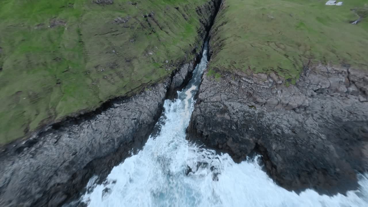 Rugged faroe coastline with crashing waves and green cliffs, aerial view
