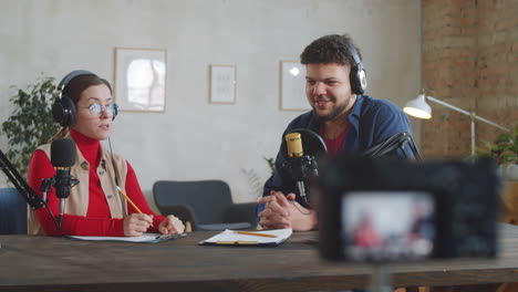 hombre positivo dando una entrevista a una podcaster