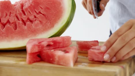 mid-section of woman cutting fruits on chopping board against white background