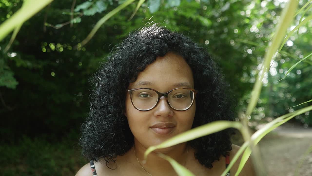 Smiling black curly curvy lady in the forest