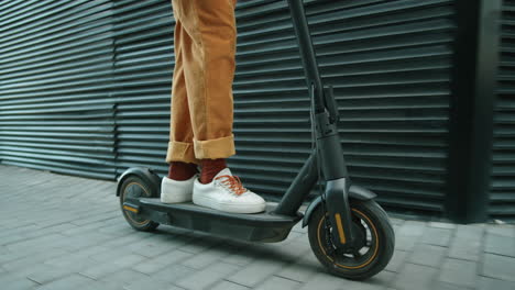 sección baja de un hombre montando un scooter eléctrico