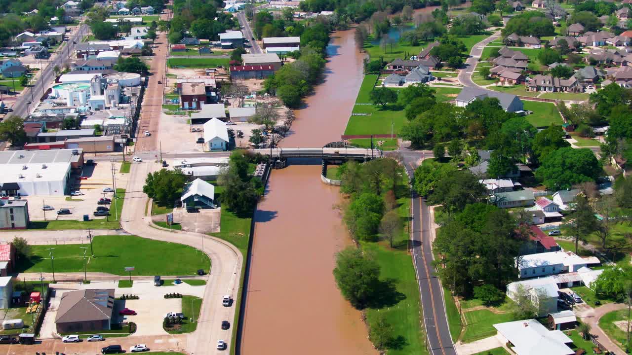 Aerial view of Bayou Teche flowing beneath Indest Street Bridge in New Iberia, LA, with downtown on one side and residential neighborhoods on the other