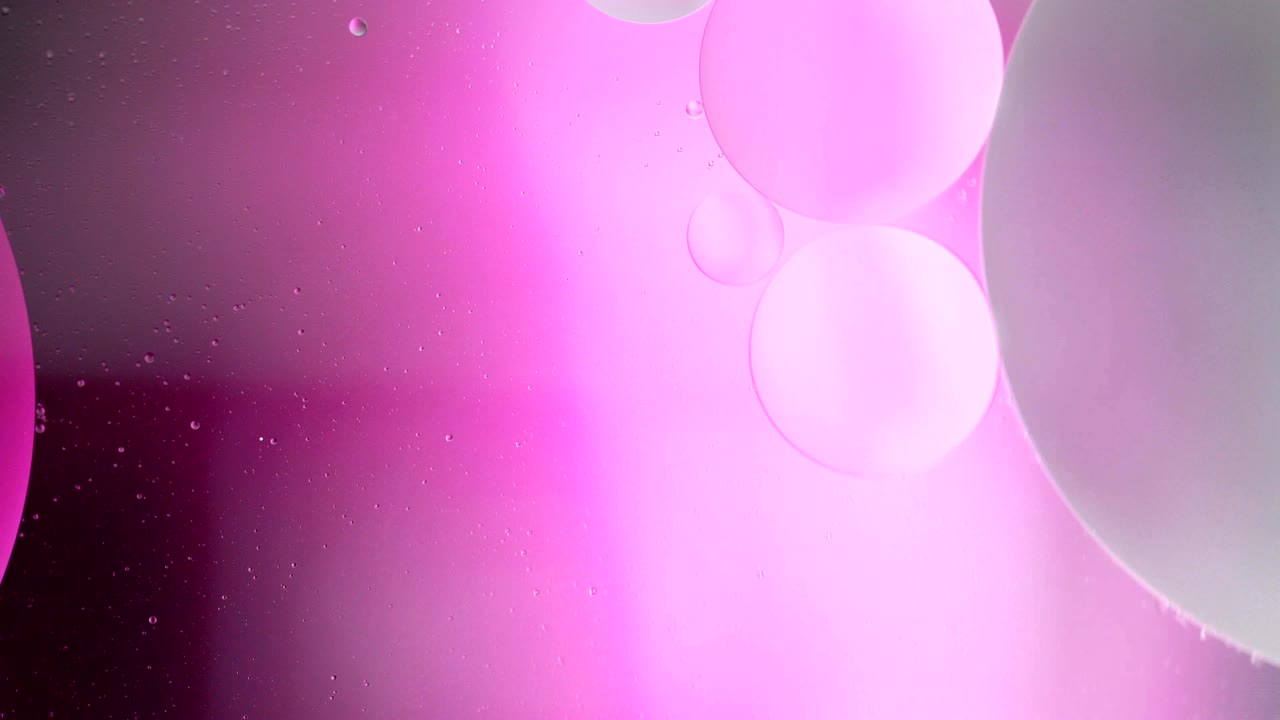 Fantastic structure of colorful bubbles. Chaotic motion. Abstract colorful paint. Top view. Movement of bubbles in the liquid. Oil surface multicolored background. Macro