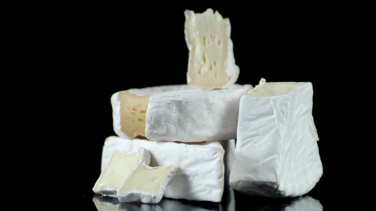 на столе медленно вращается нарезанный сыр камамбер.