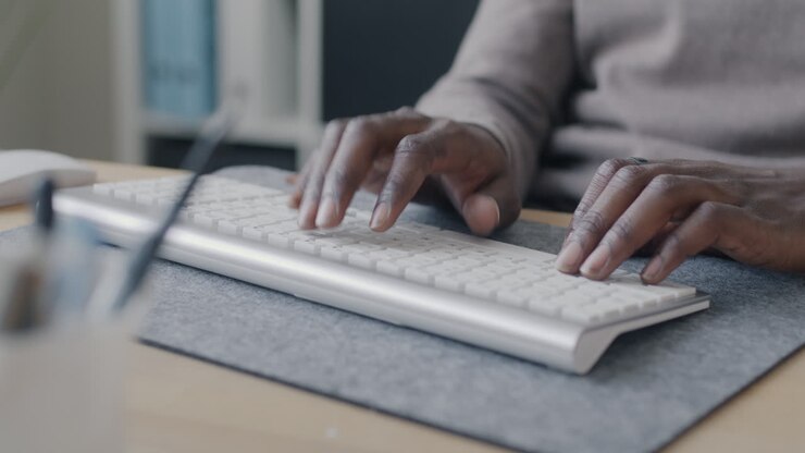 Person, die auf einer Tastatur tippt