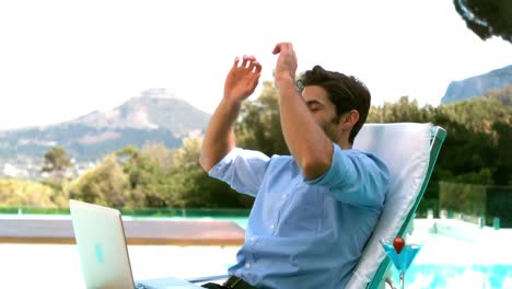 hombre de negocios usando una computadora portátil en una silla de sol