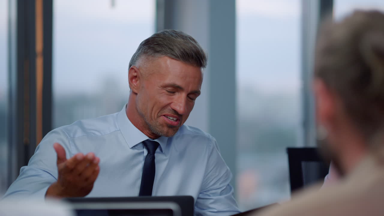 Uomo d'affari parla con cliente in ufficio. Consulente assiste il cliente.