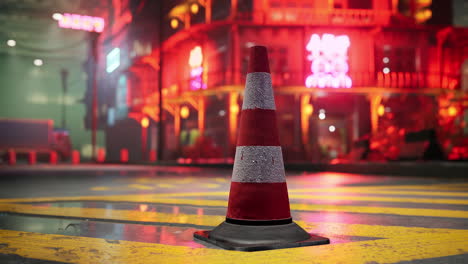 cono de tráfico en una calle húmeda de la ciudad por la noche