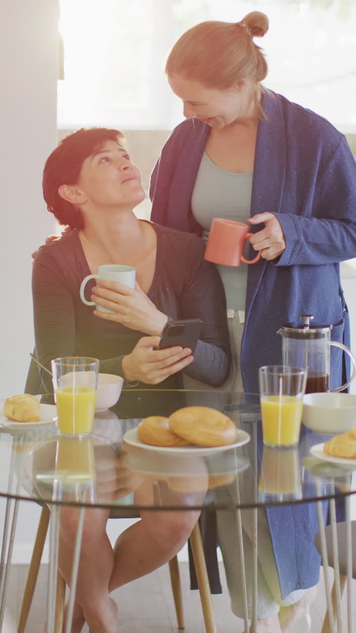 가정에서 아침 식사를 하는 행복한 백인 레즈비언 커플의 수직 비디오