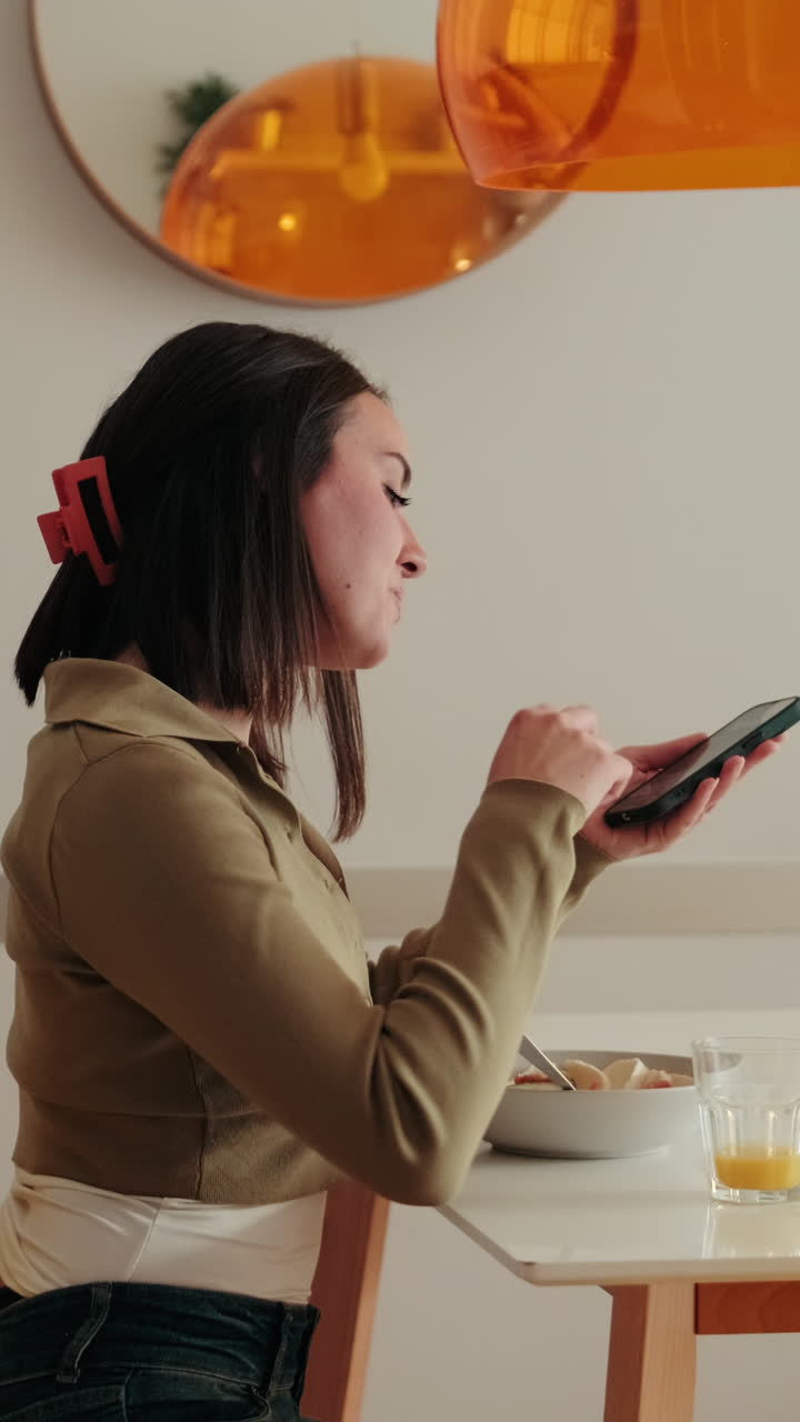 Side view of Woman Enjoys Breakfast and Smartphone