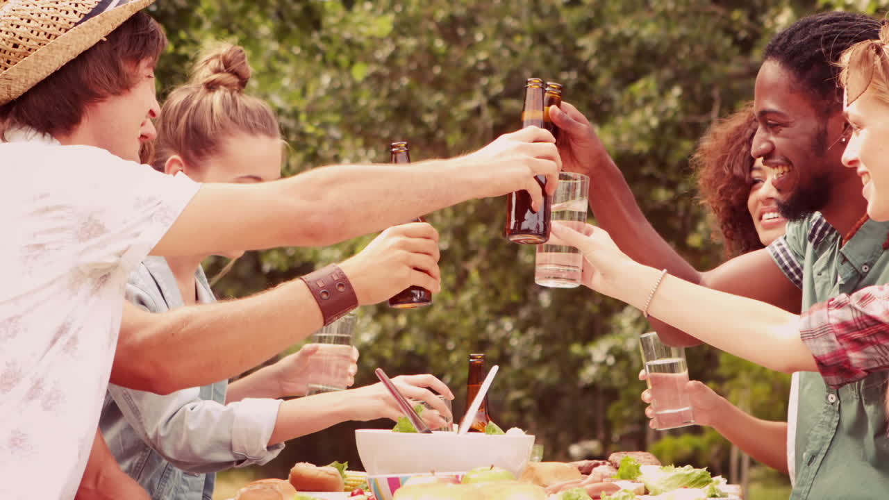 느린 동작으로 공원에서 점심을 먹는 행복한 친구들