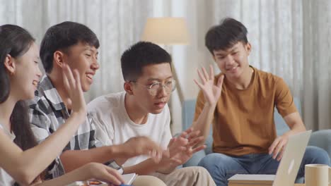 close up of asian teen group studying online at home. having video conference on laptop, smiling, waving hands