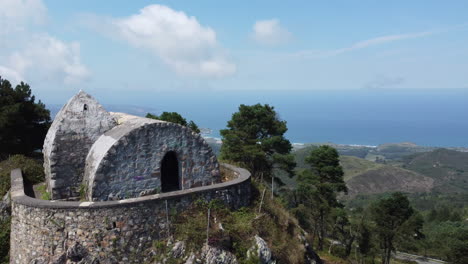 drone pasando por una casa de piedra en medio de una montaña