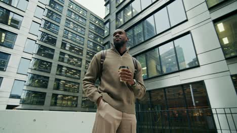 businessman walking in city with coffee