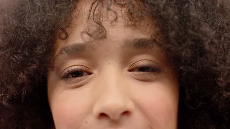 Portrait-close-up-of-the-eyes-of-biracial-creative-businesswoman-smiling-in-office,-in-slow-motion