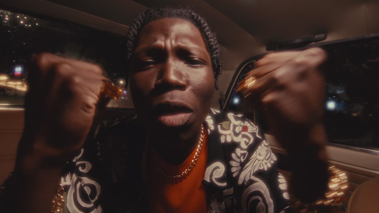 Black Hip-Hop Performer Rapping to Camera during Car Ride in City