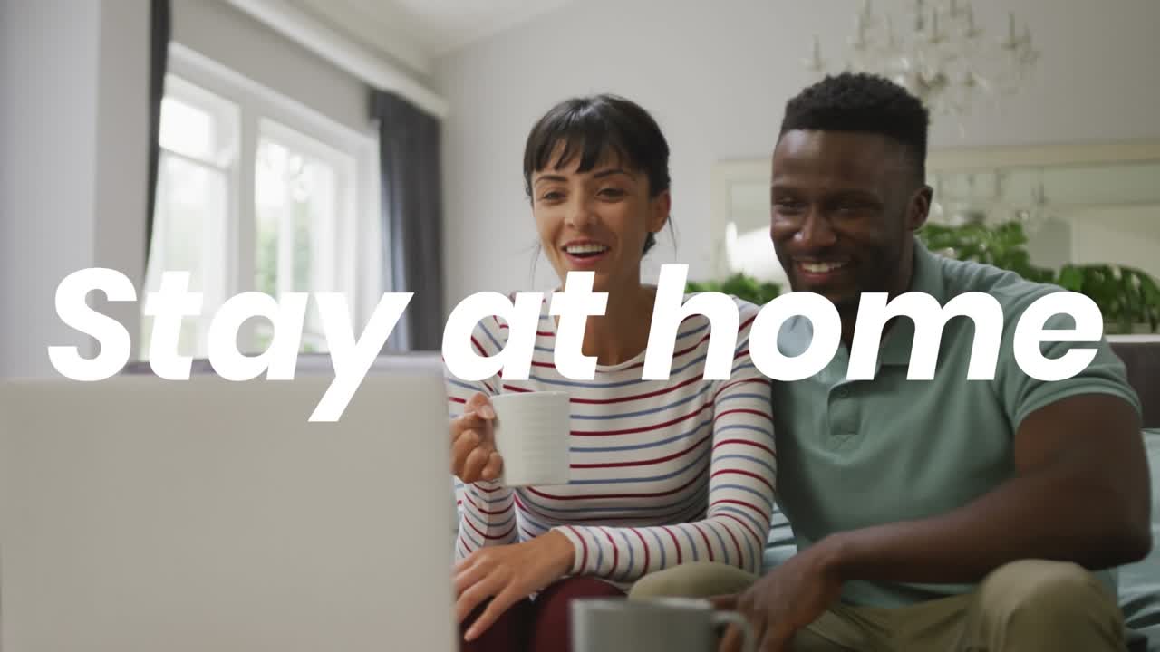 Animation du texte "restez à la maison" sur un couple diversifié utilisant un ordinateur portable.