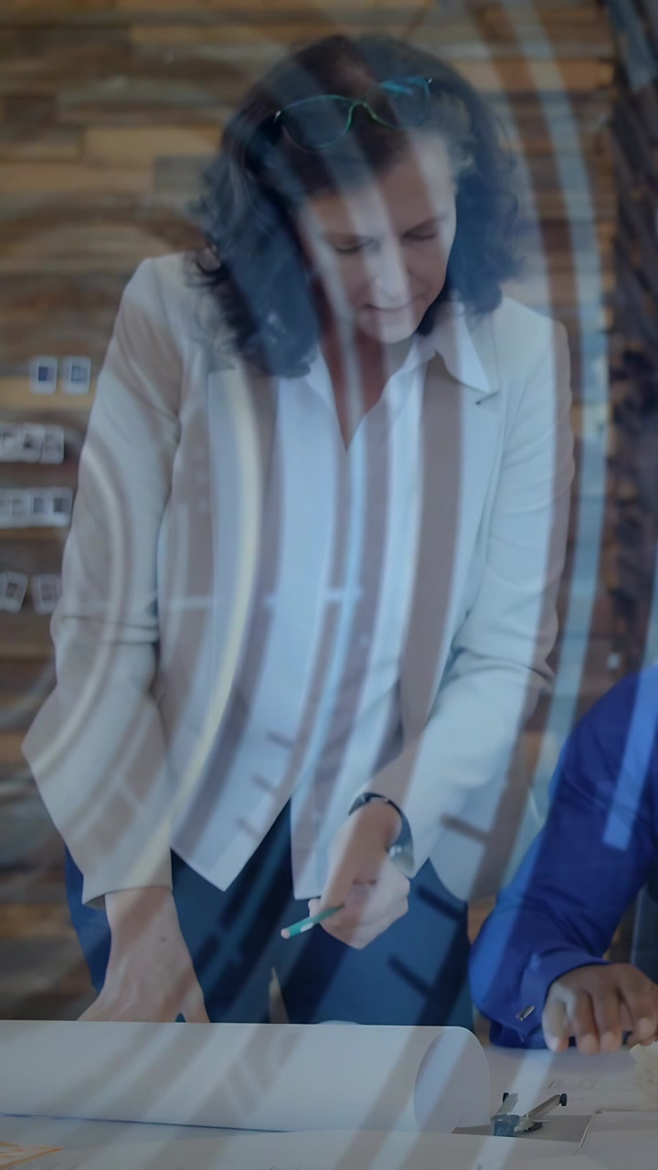 Video verticale: Donna che indica con una penna verde, avvia una revisione in ufficio, uomo che evidenzia il piano sotto archi di luce.