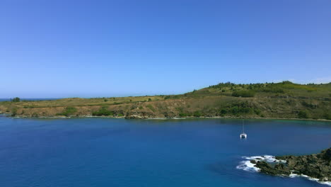 coast and ocean aerial panorama, single catamaran boat, paradise vacation