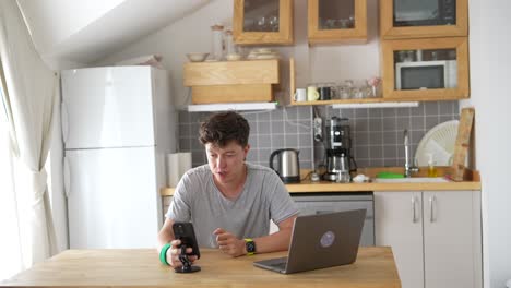 joven trabajando desde casa en la cocina
