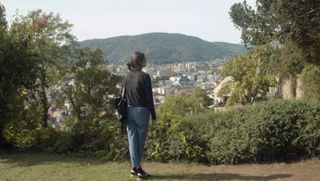 girl looks at the city of graz from schlossberg hill wide shot