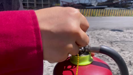 hand of people is removing seal on the fire extinguisher