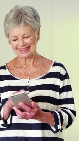 una mujer mayor usando su teléfono inteligente.