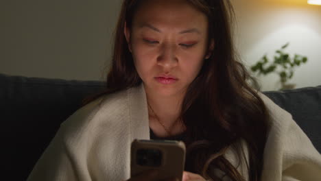 Stressed Anxious Woman Spending Evening At Home Sitting On Sofa Reacting To Internet Or Social Media News Message Or Story On Mobile Phone 2