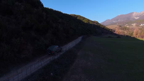 Toma-Real-De-Coche-De-Rally-Conduciendo-Rápido-Bajo-Una-Colina-En-Pista-De-Tierra