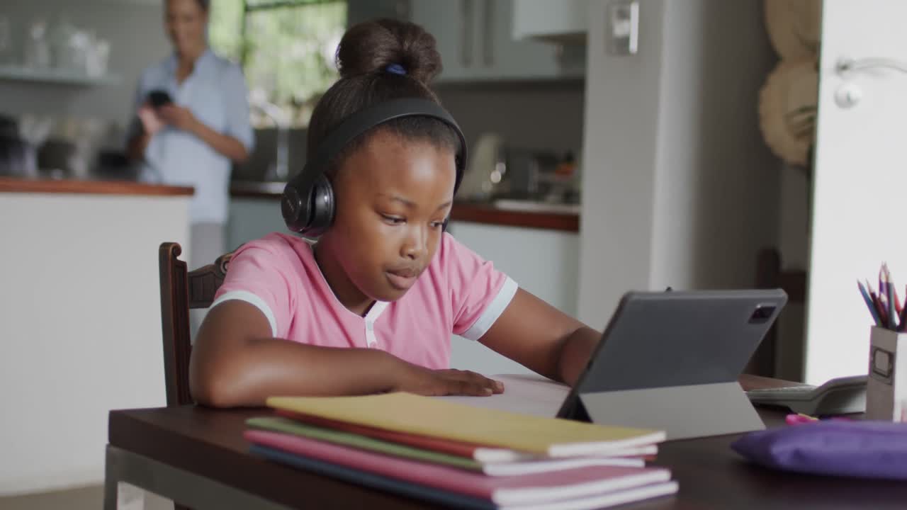 African american girl using tablet and doing homework, slow motion