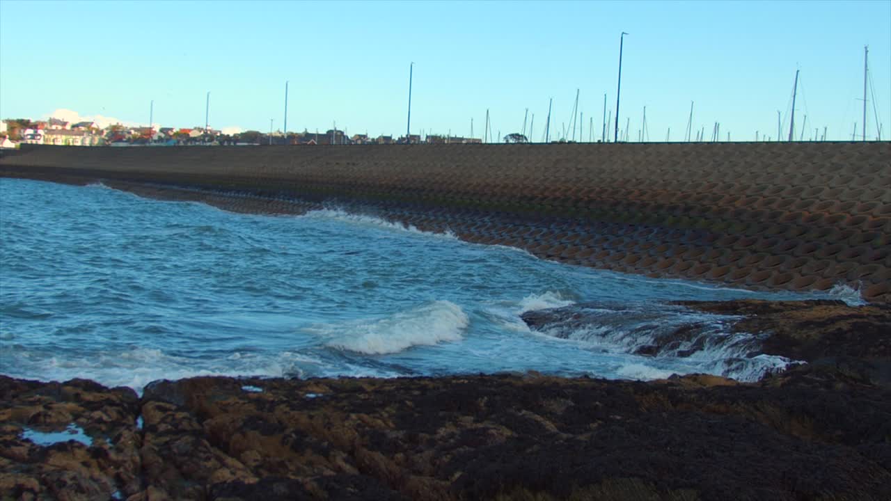 esta es una foto estática del océano. las olas chocan contra un dique en el muelle de bangor, irlanda del norte.
