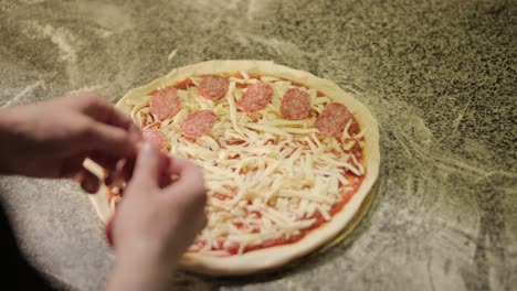 chef preparing pizza toppings in a restaurant kitchen